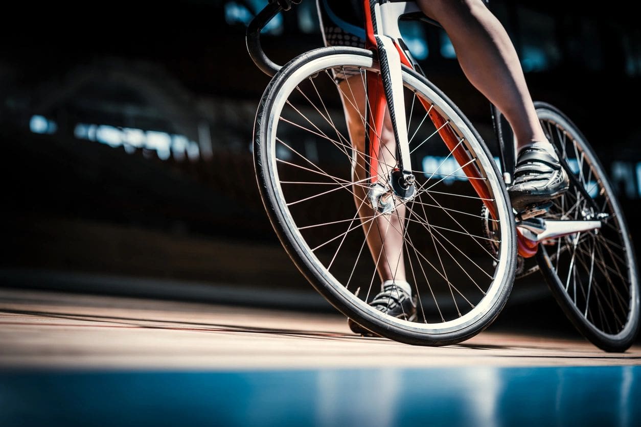 Cyclist riding a bicycle on indoor track.